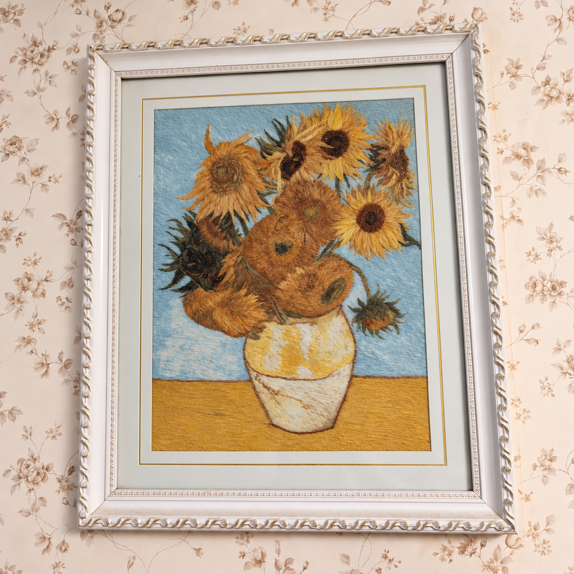 My mom’s framed sunflower embroidery, hanging at home.
